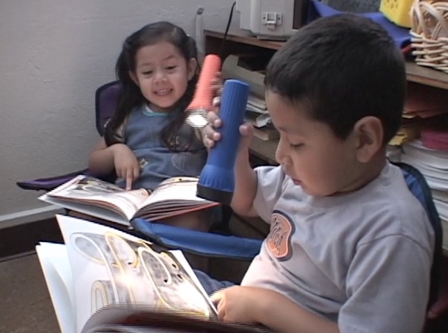 Bilingual, four-year-old children, Elizabeth, Eduardo, & Emily, read the book, Whose Mouse are You? with flashlights