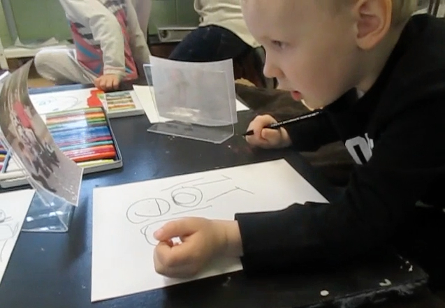 four-year old boy draws from family photograph
